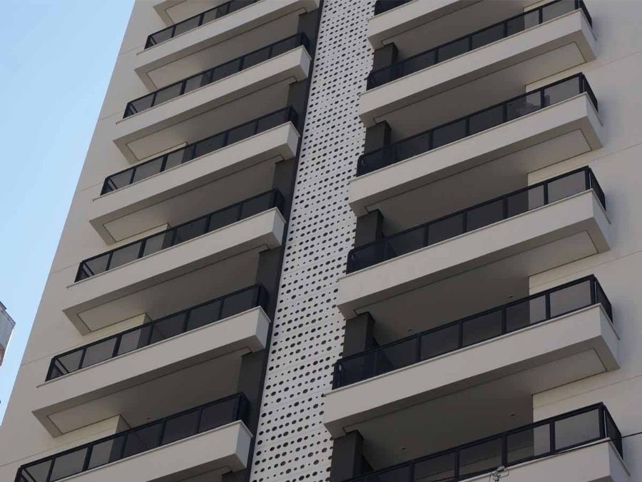 Fachada de edifício residencial vista de baixo, com sacadas e guarda-corpos de vidro